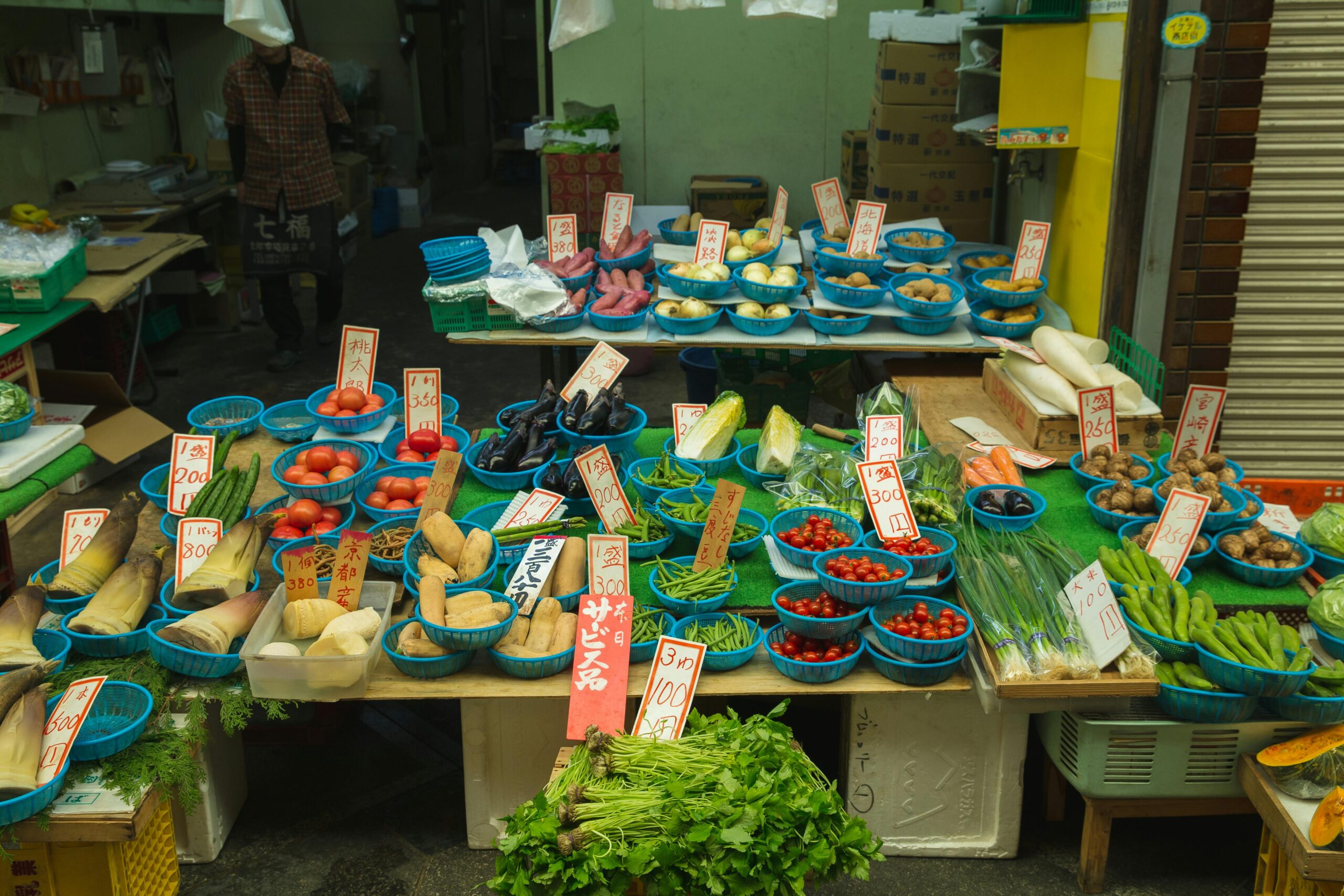 Japanese trader selling fresh tomatoes and other fresh vegetables to customers in the street market