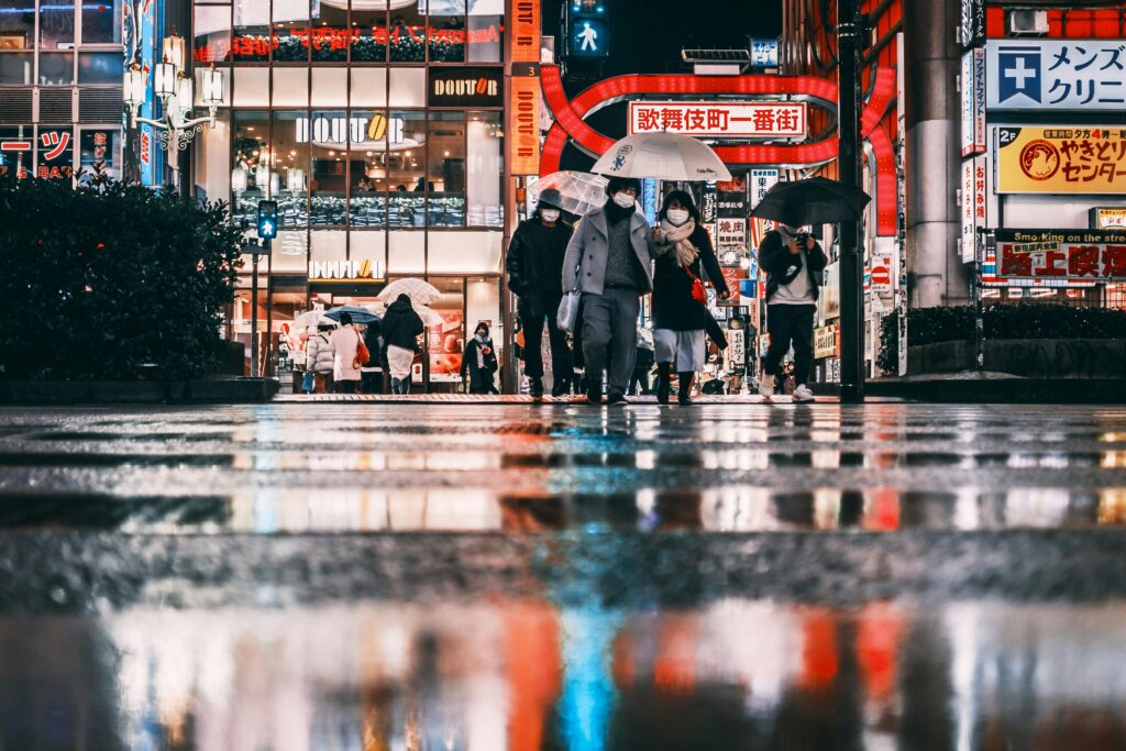 pexels-photo-6635773-6635773 Night city with people in mask on crosswalk near buildings